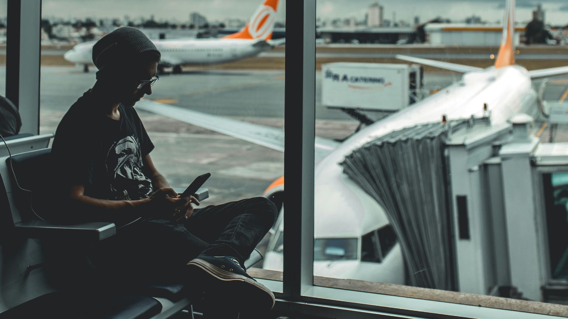 man browsing his phone in airport