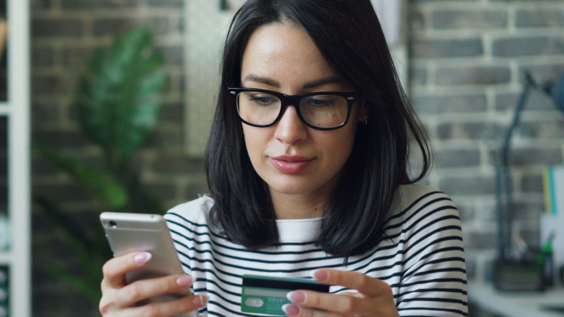 a woman sitting at a table looking at her cell phone
