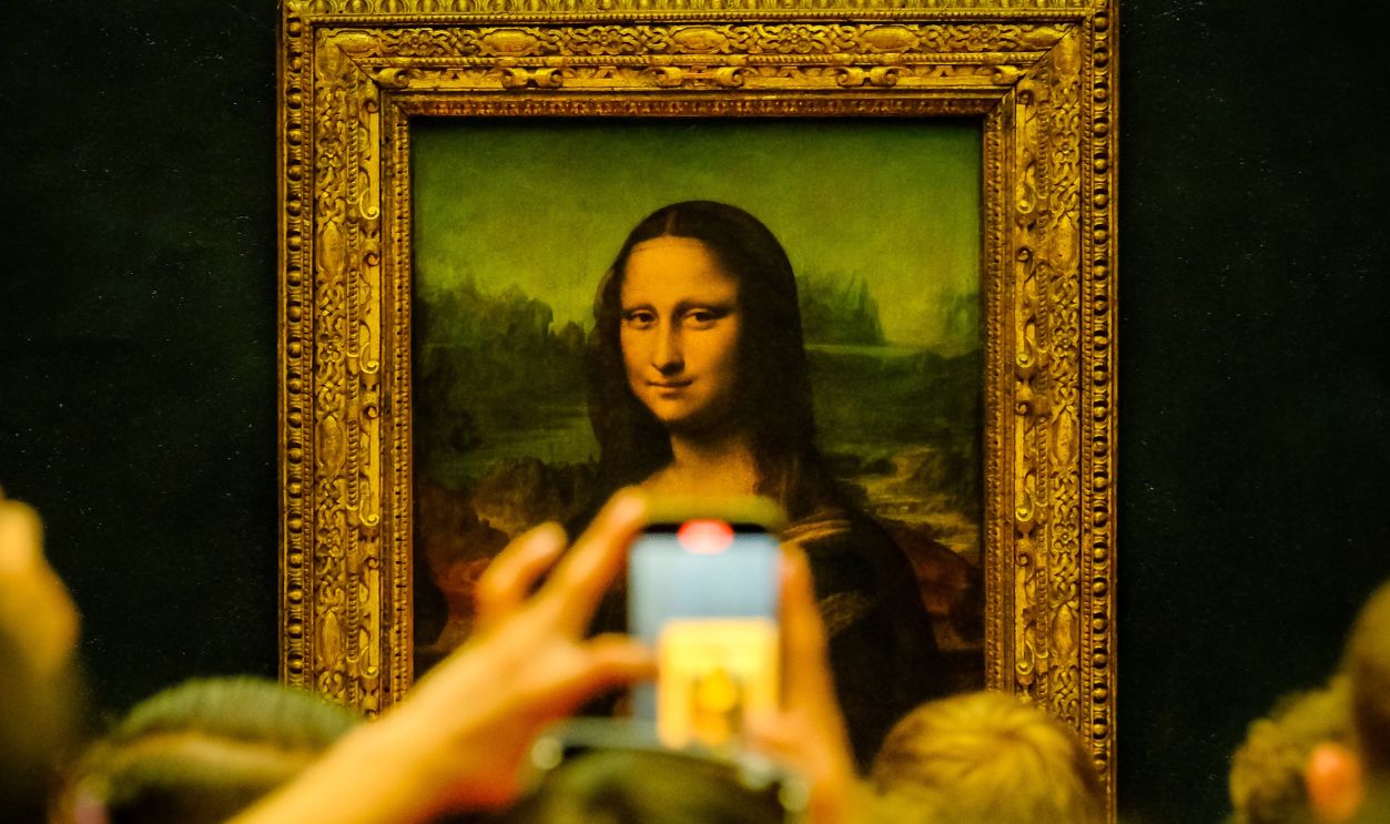 Crowd admiring the Mona Lisa painting at the Louvre Museum in Paris with phones capturing the moment