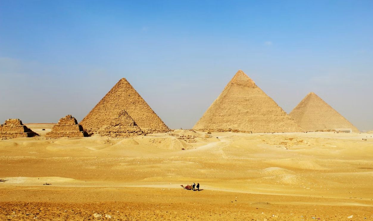 a group of pyramids in the desert with a sky background
