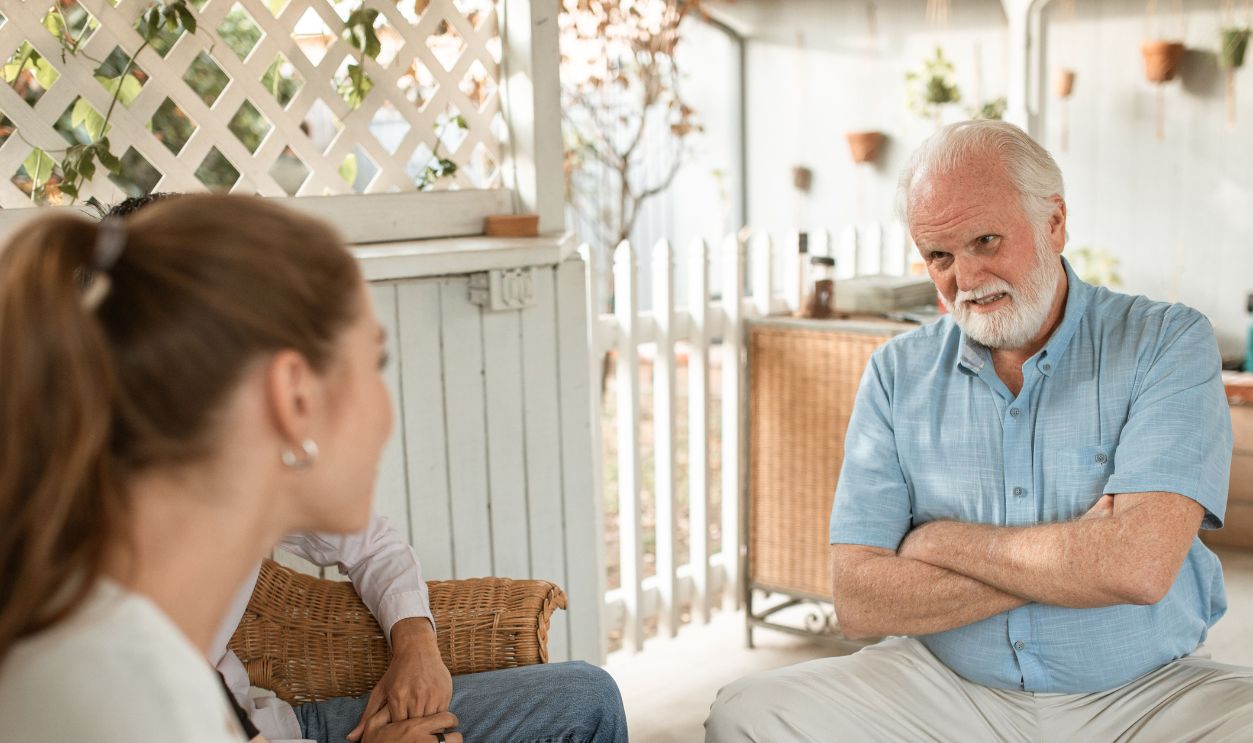 Senior man and two adults having a friendly conversation