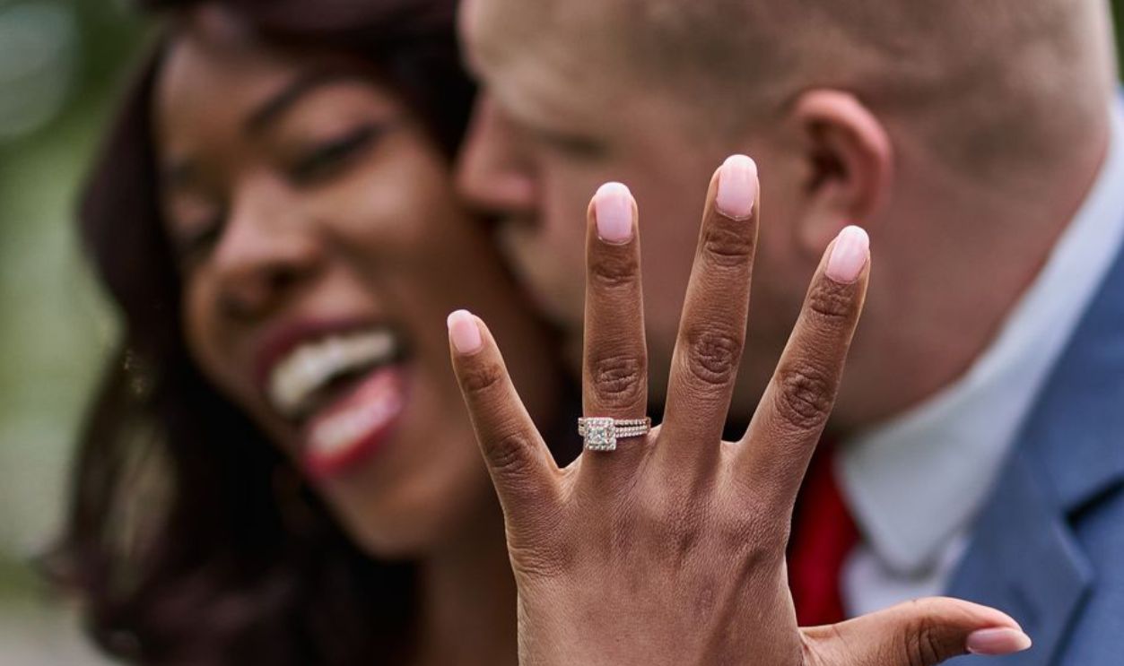 A happy couple celebrating their engagement with a focus on the engagement ring.