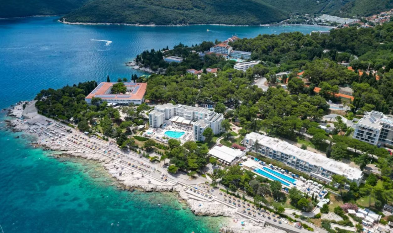 Stunning aerial view of Rabac's coastline with hotels, turquoise waters, and lush greenery in Istria, Croatia