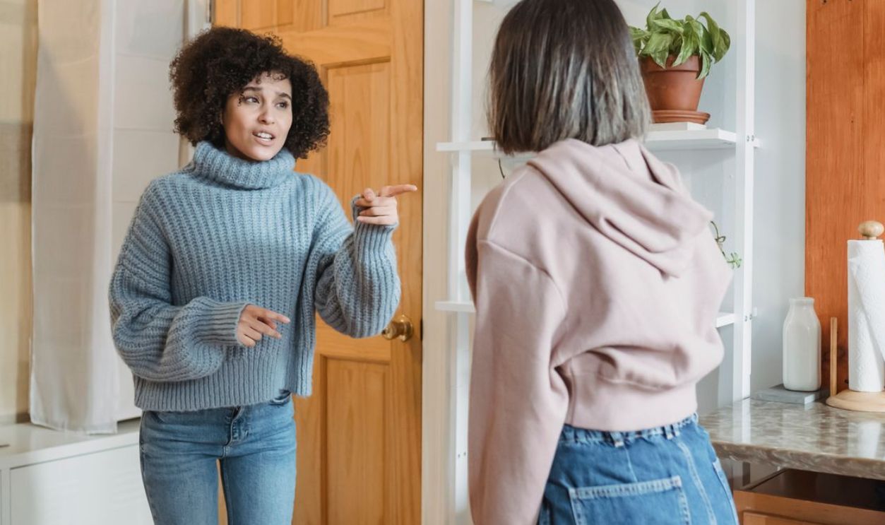 Two women having an expressive debate in a cozy apartment interior