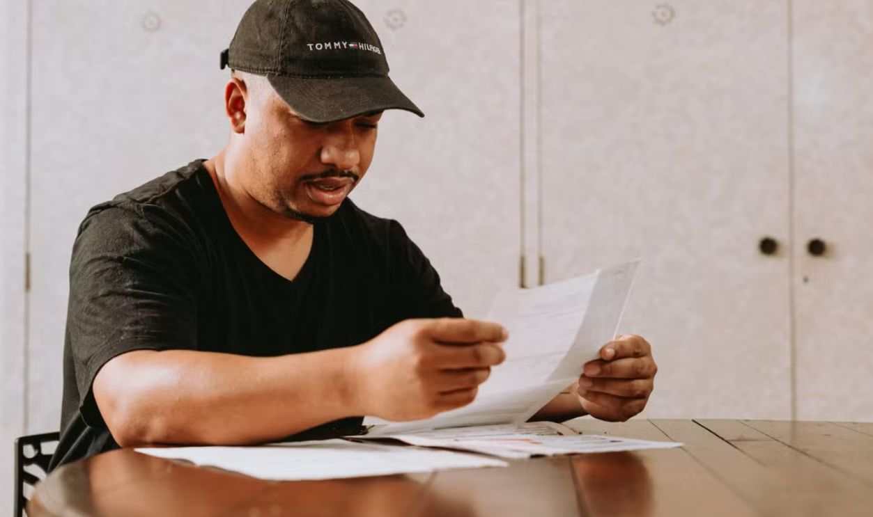 Adult man sitting at home table, focused on reviewing important documents