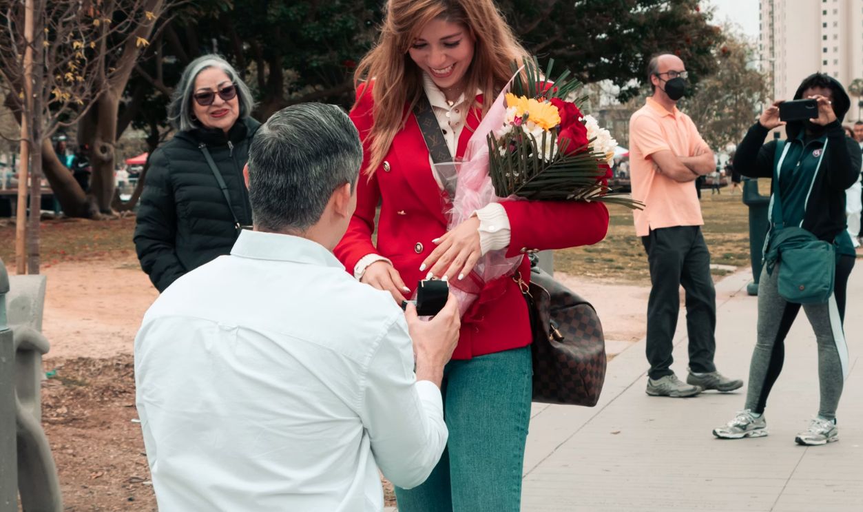 a man kneeling down to pick up a woman