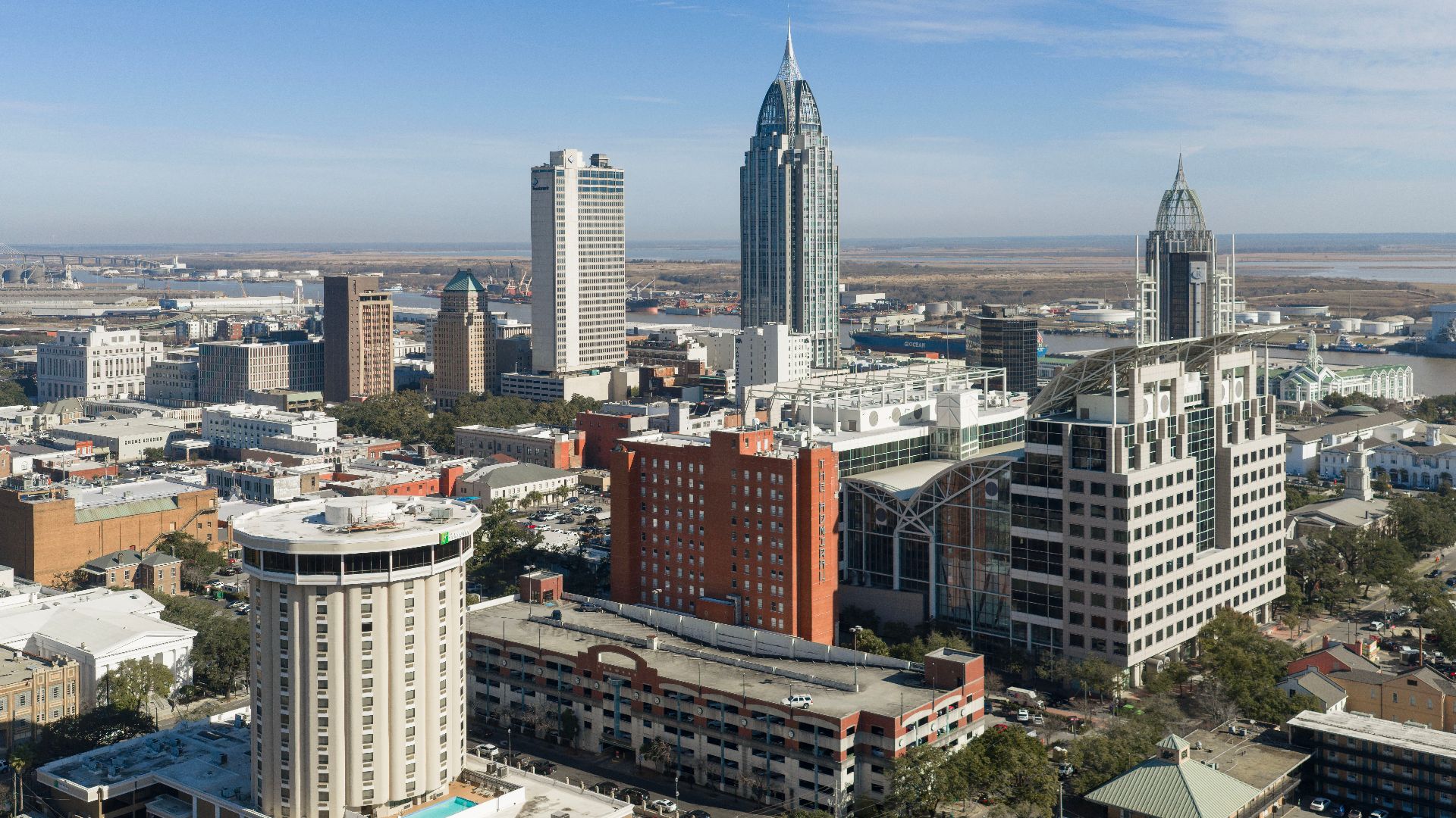 Skyline of Mobile, Alabama, viewed from the west, with downtown buildings along the Mobile River.