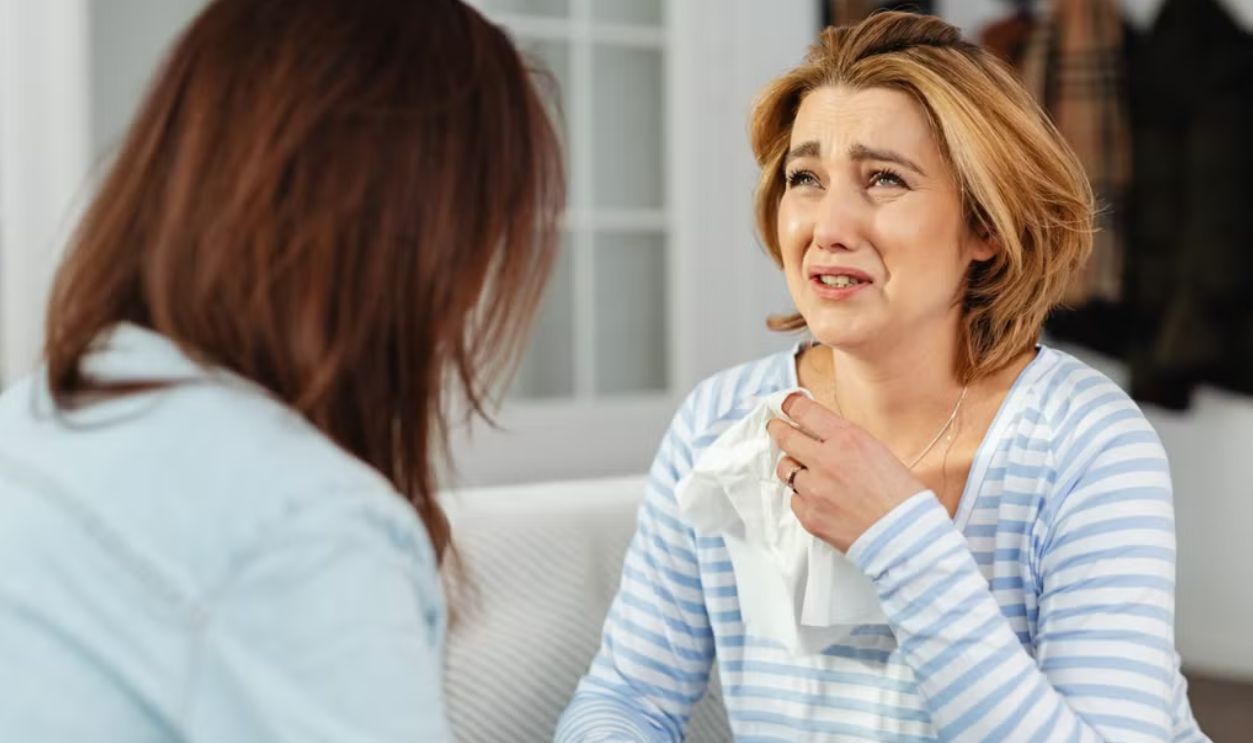 A woman receiving comfort from a friend, illustrating empathy and support in a difficult moment.