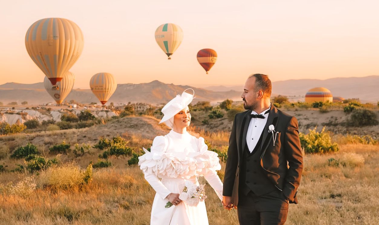 Bride and groom with hot air balloons at sunset, creating a magical wedding moment