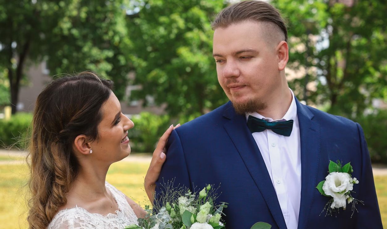 man in blue suit and woman in white wedding dress