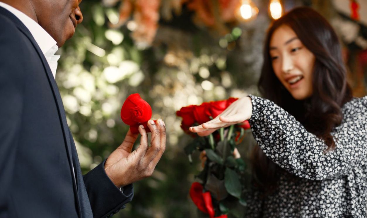 A joyous marriage proposal featuring a red rose bouquet and a ring, capturing love and excitement