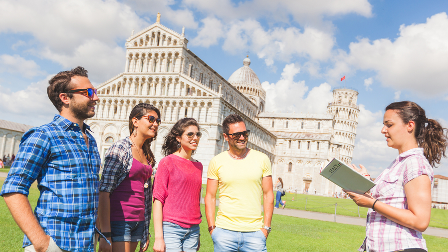 Group of tourists in Pisa, Italy listening to a guide