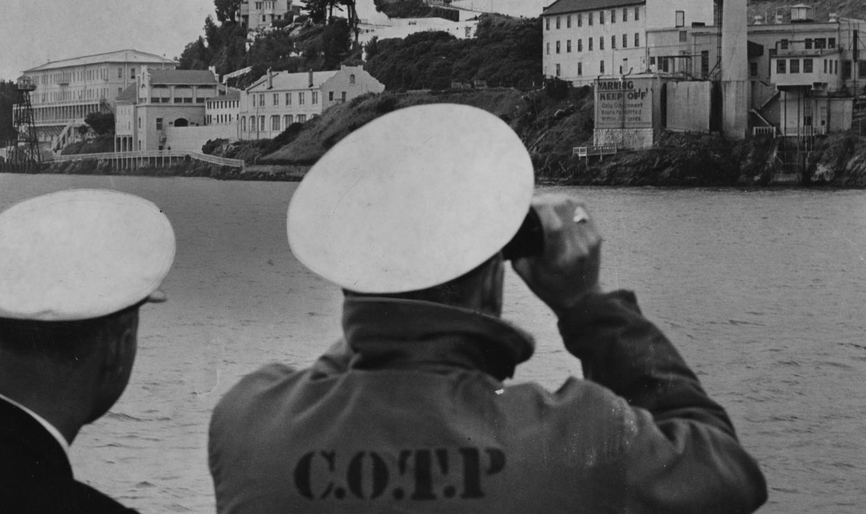 Coast guard officers looking at Alcatraz Federal Prison, through binoculars after an escape;Photo shot 06/12/1962;Photo ran 06/13/1962, p. 3Ca Coast guard officers looking at Alcatraz Federal Prison, through binoculars after an escape;Photo shot 06/12/1962;Photo ran 06/13/1962, p. 3Ca