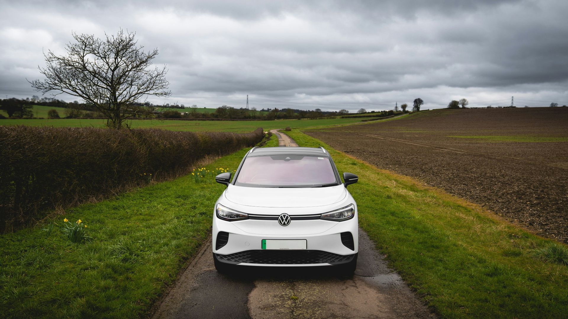 White electric car parked on a rural road