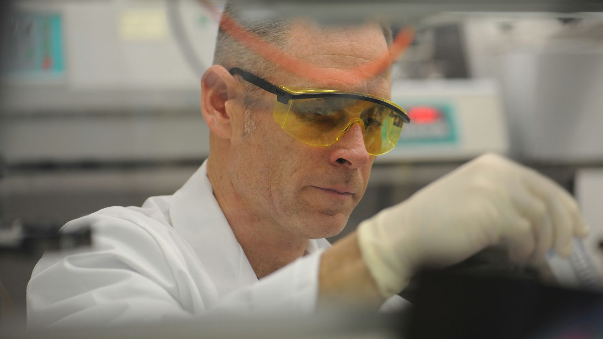 a man in a lab wearing safety goggles