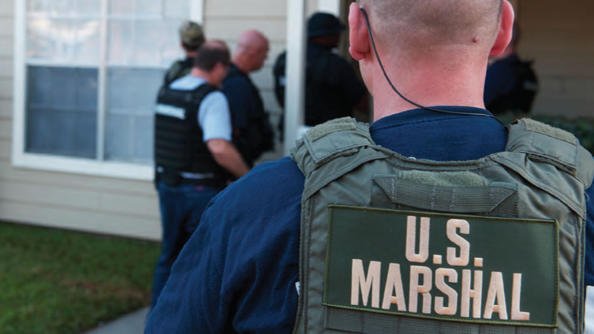 United States Marshals entering a building.