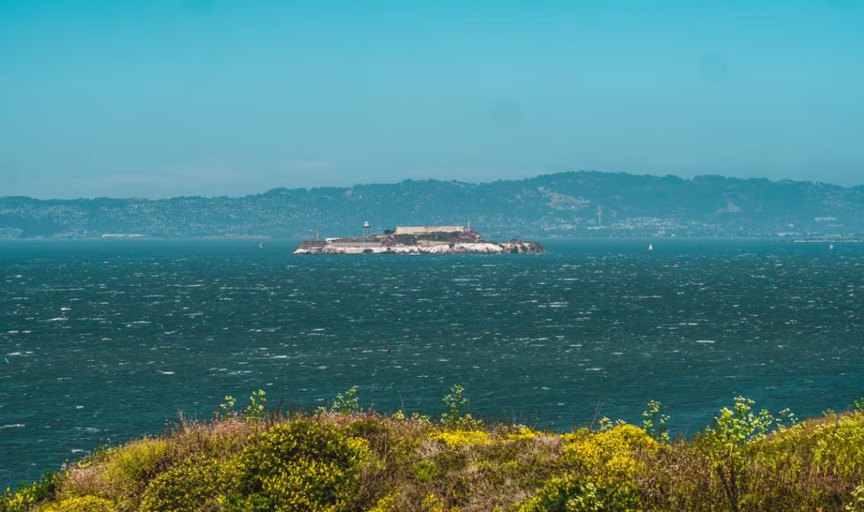 Picturesque view of Alcatraz Island surrounded by San Francisco Bay under clear sky