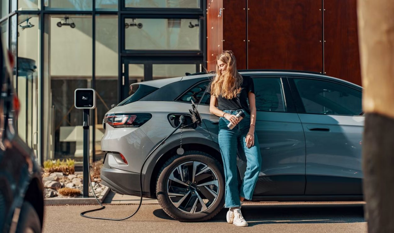 a woman standing next to a blue car