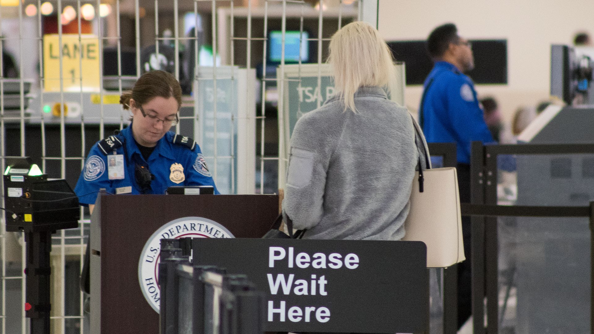 A Transportation Security Administration agent at a checkpoint verifying passenger identification, John Glenn Columbus International Airport