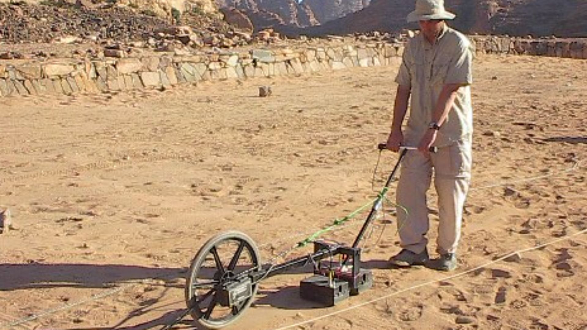Ground penetrating radar (GPR) survey at the Nabataeo-Roman site of Wadi Ramm, Jordan. The wheel trailing behind the transmitter/receiver antennas is an odometer that controls data collection.