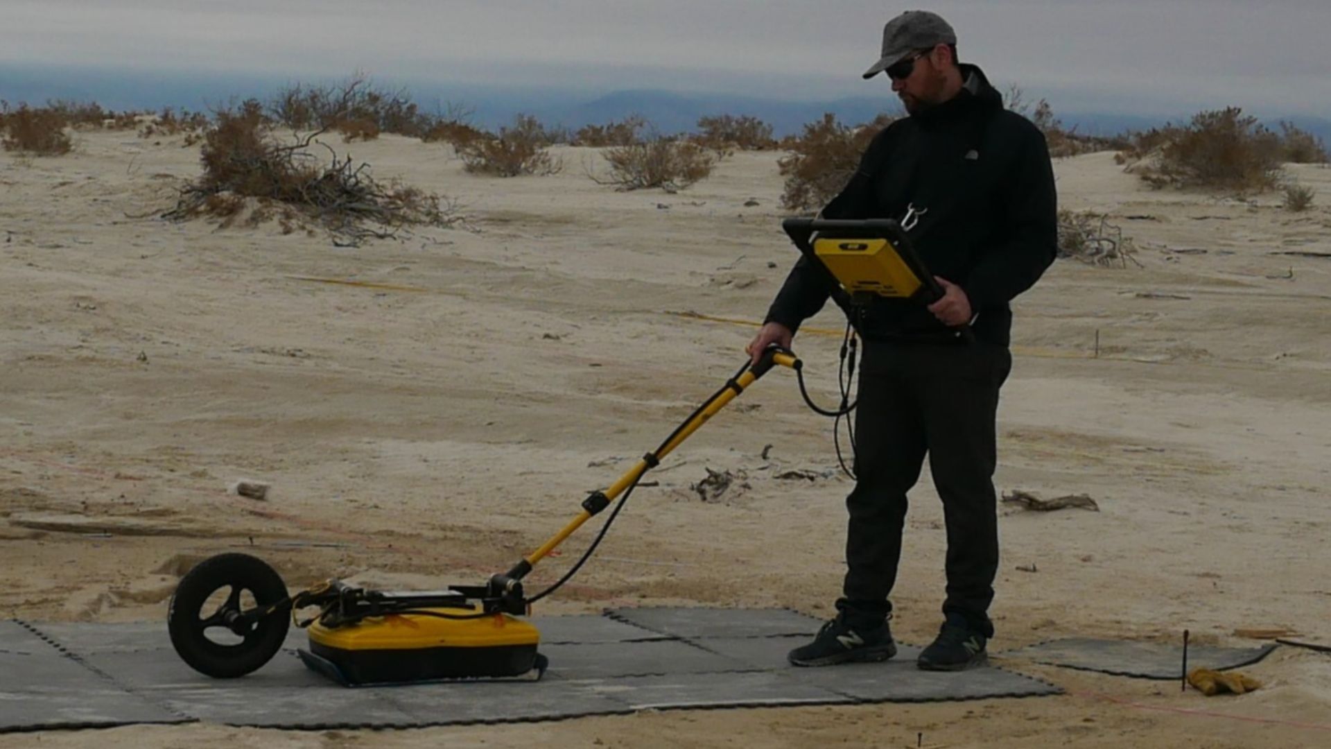 A researcher uses a Ground Penetrating Radar (GPR) device to identify footprints and create a visual data map of their size and location.
Ground Penetrating Radar (GPR) is a popular technique that is used in archeology to identiy areas of interest and pot