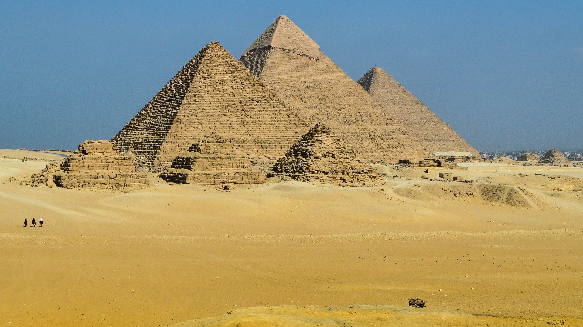 Pyramids of Giza is an archaeological site on the Giza Plateau, on the outskirts of Cairo, Egypt. This complex of ancient monuments includes the three pyramid complexes known as the Great Pyramids, the massive sculpture known as the Great Sphinx, several 