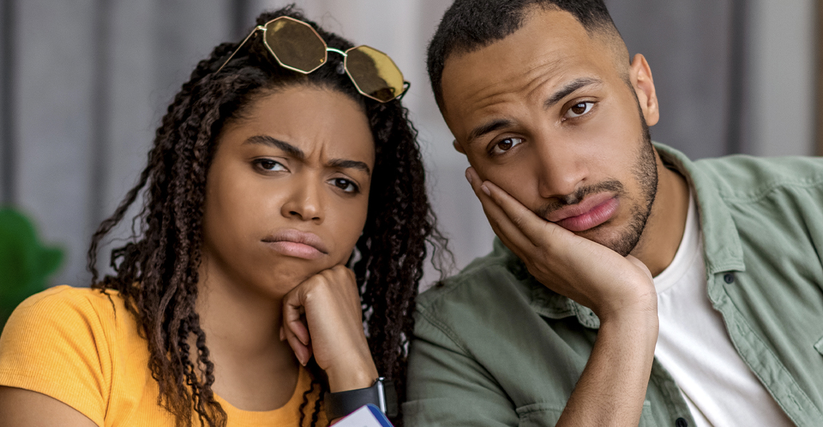 Unimpressed Black couple with yellow suitcase.