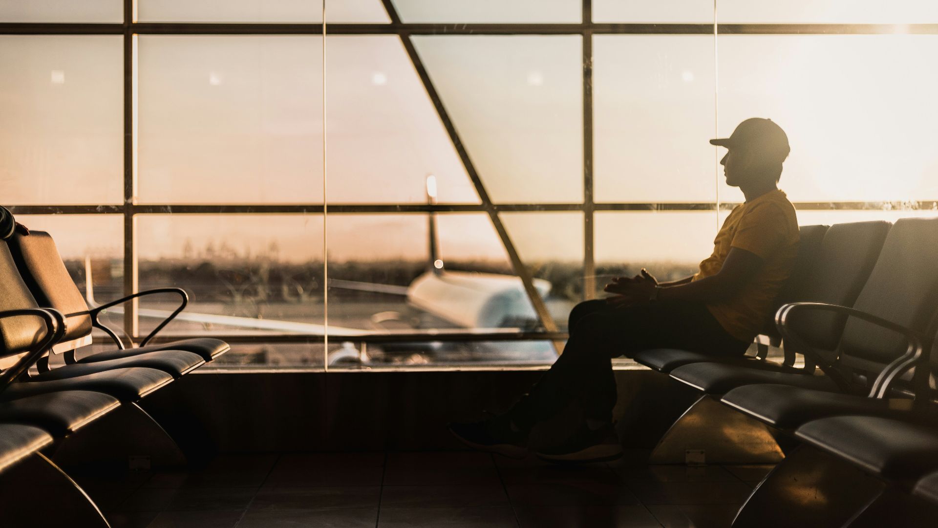 man sitting on gang chair near window
