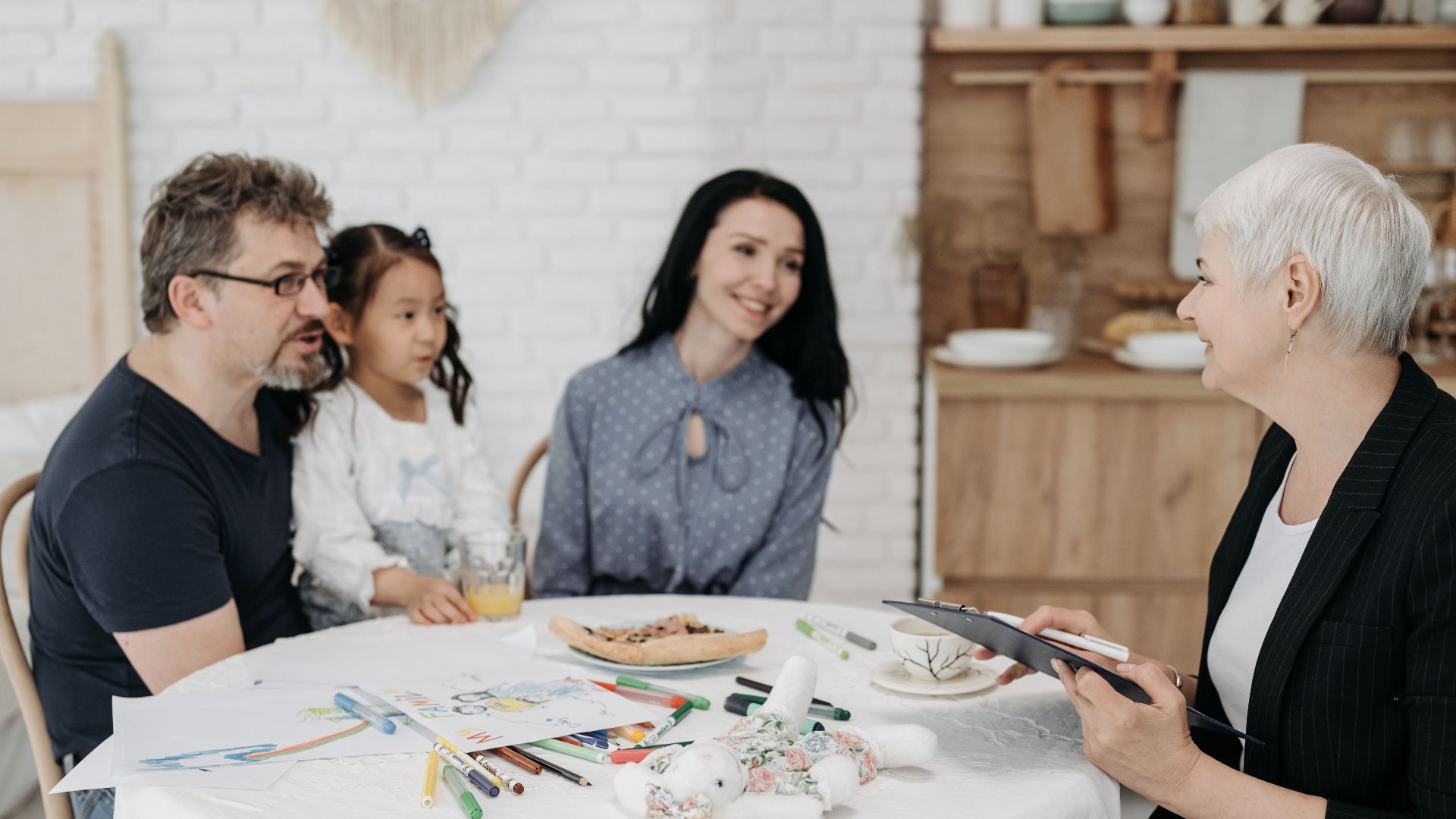 Adoptive family discussing with a social worker indoors, creating a warm, welcoming atmosphere.