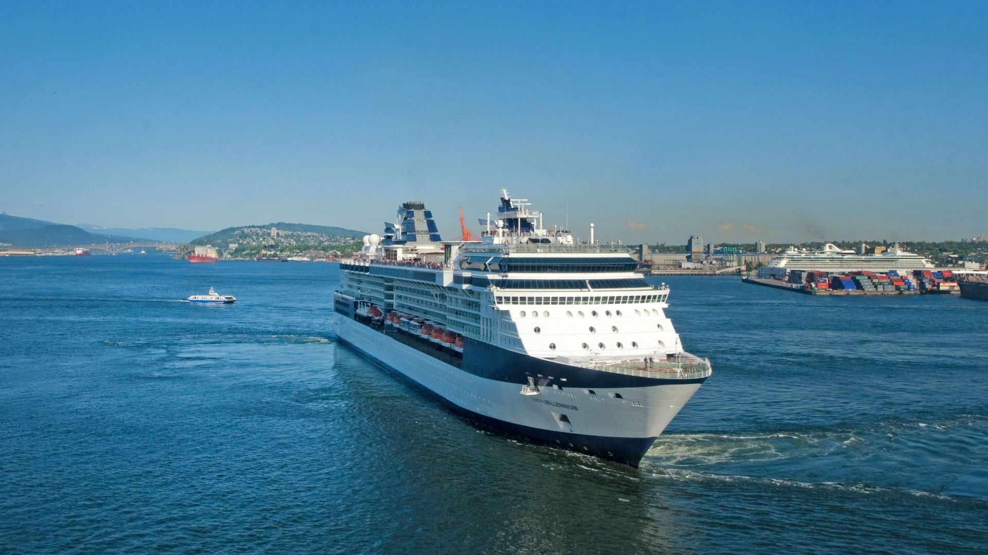A large cruise ship sailing through calm waters under a clear blue sky, perfect for a relaxing vacation.
