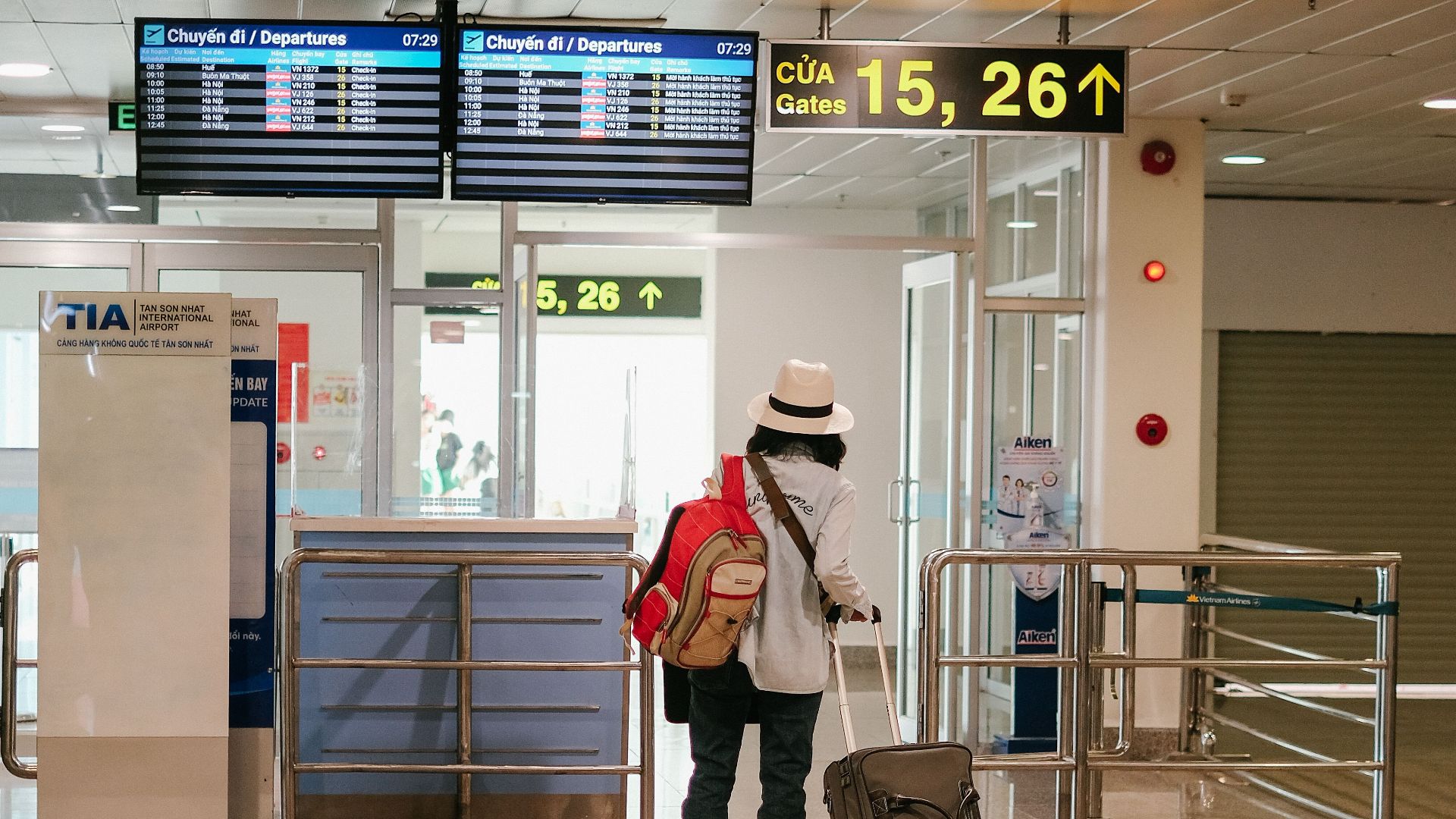 Woman with luggage exploring airport terminal. Solo travel and future adventures.