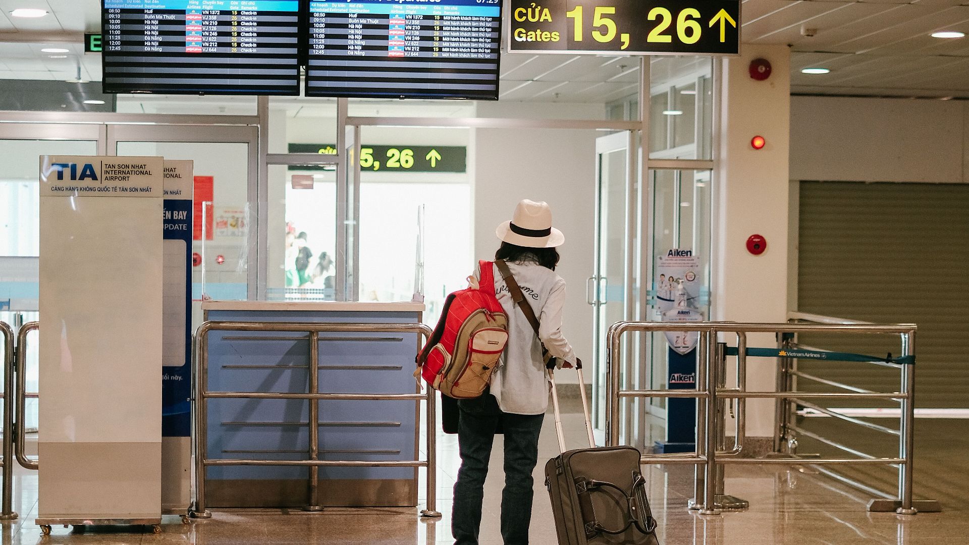 Woman with luggage exploring airport terminal. Solo travel and future adventures.