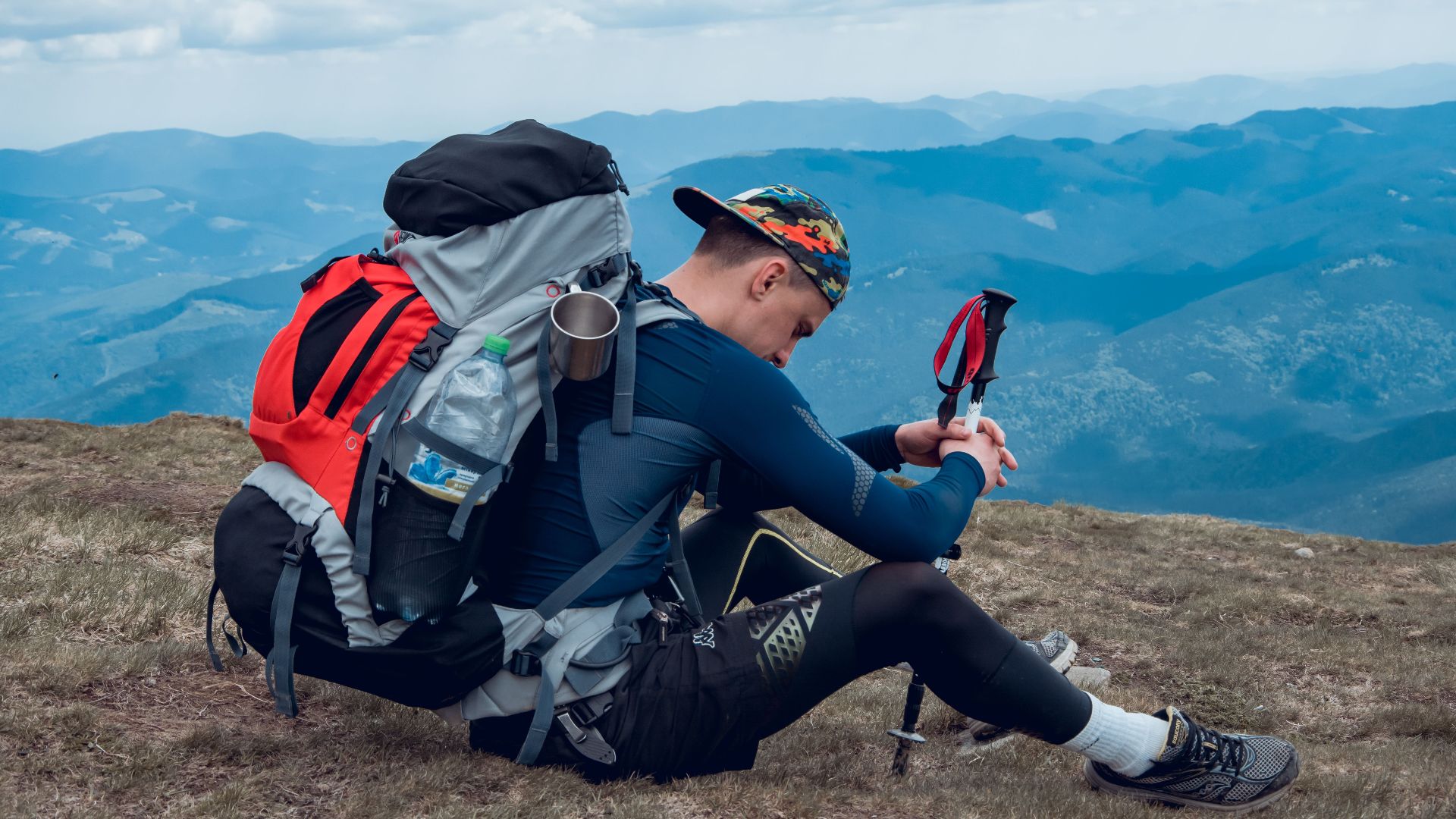 Man resting with backpack on a mountain top in Zakarpattia Oblast, Ukraine. Outdoor adventure.