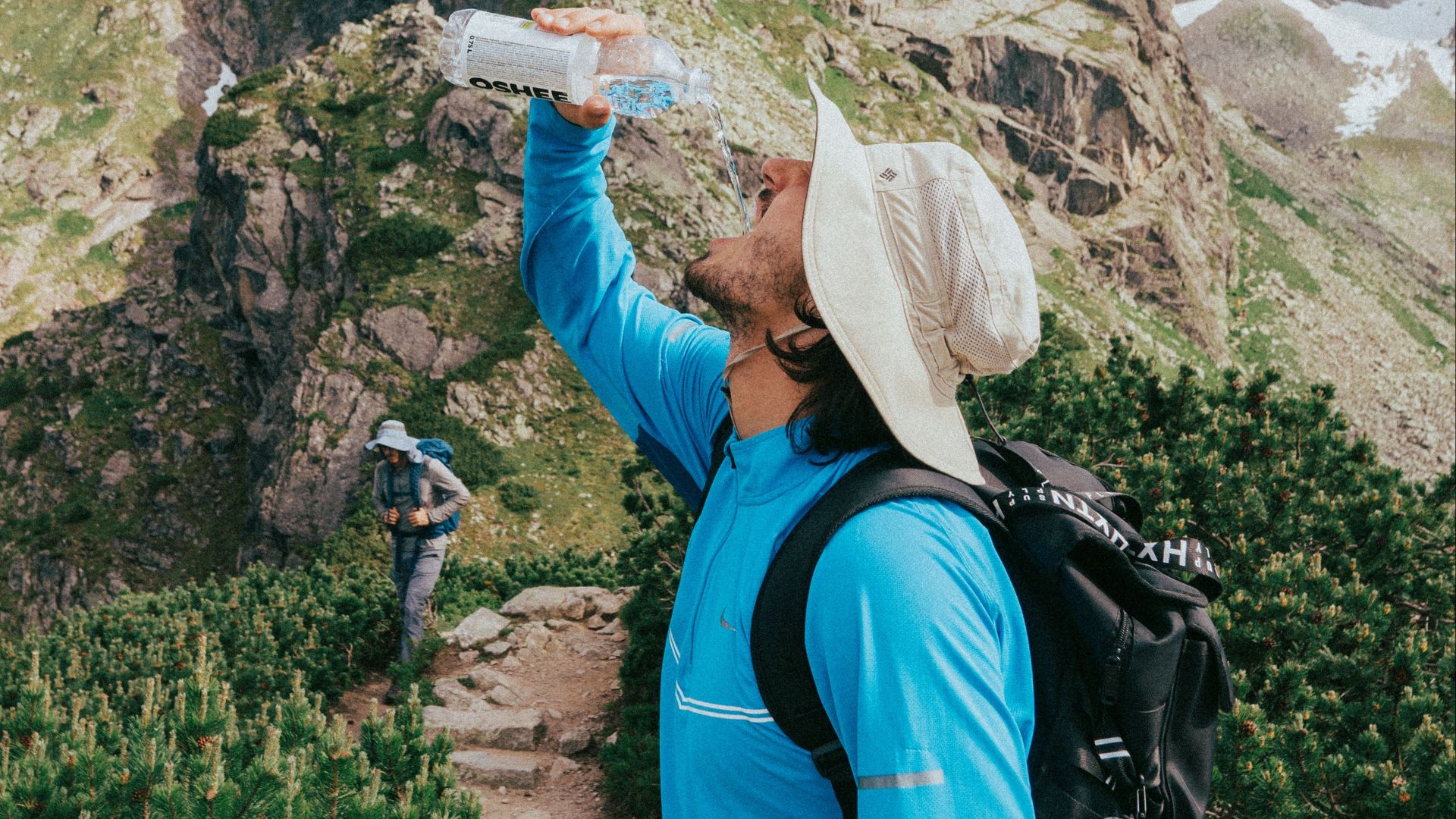 Man drinking water while hiking in the Tatra Mountains, Poland.