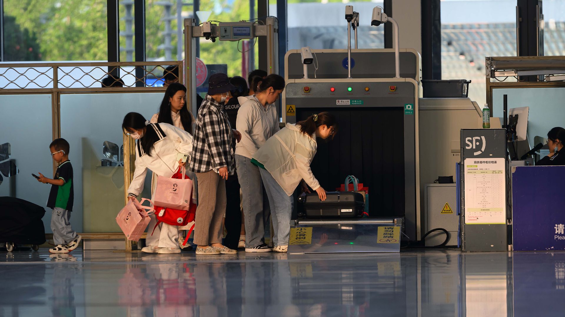 Travelers undergo security screening at an airport terminal.