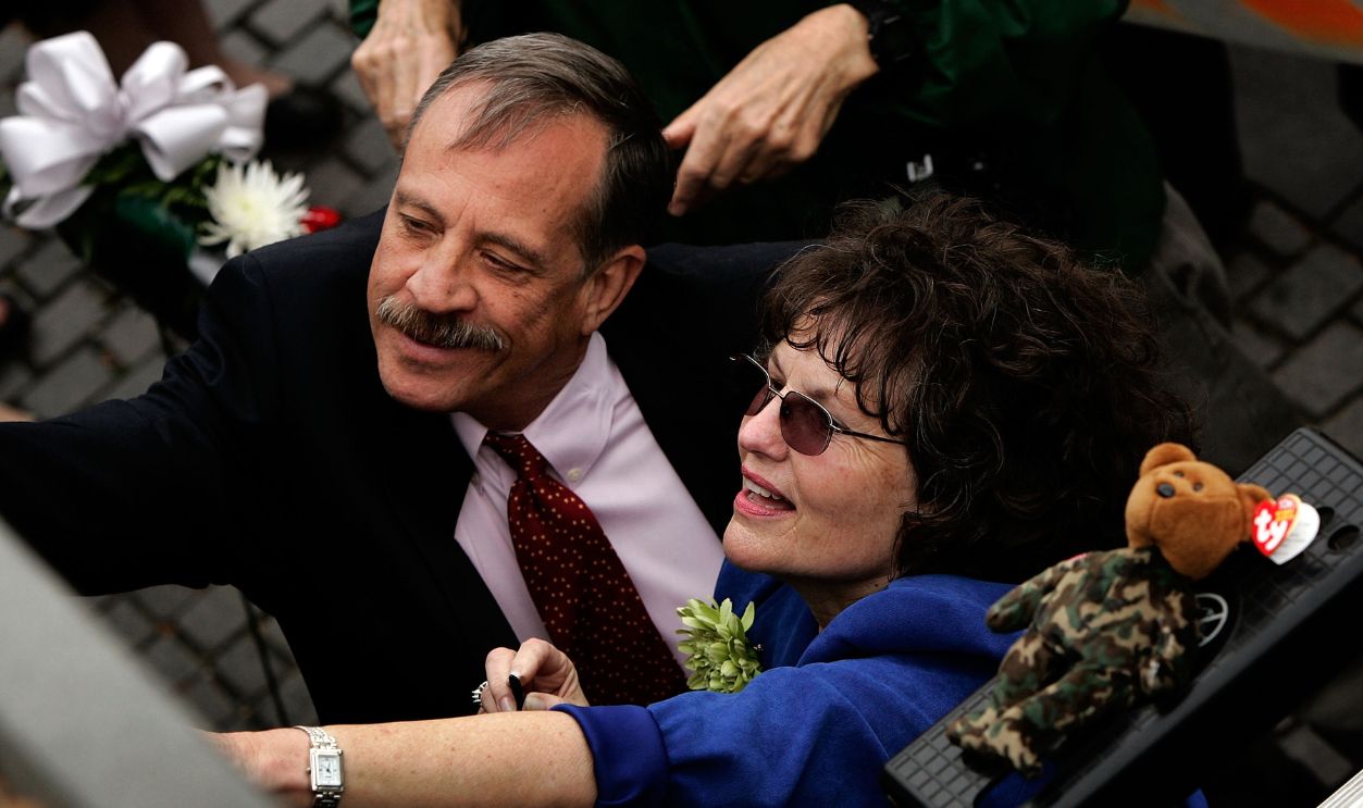 Ann Pruett (R) and Vietnam Veterans Memorial Fund founder and president Jan Scruggs (L) reach to make a graphite rubbing of Pruett's husband's name on the Vietnam Veterans Memorial May 3, 2007 in Washington, DC.