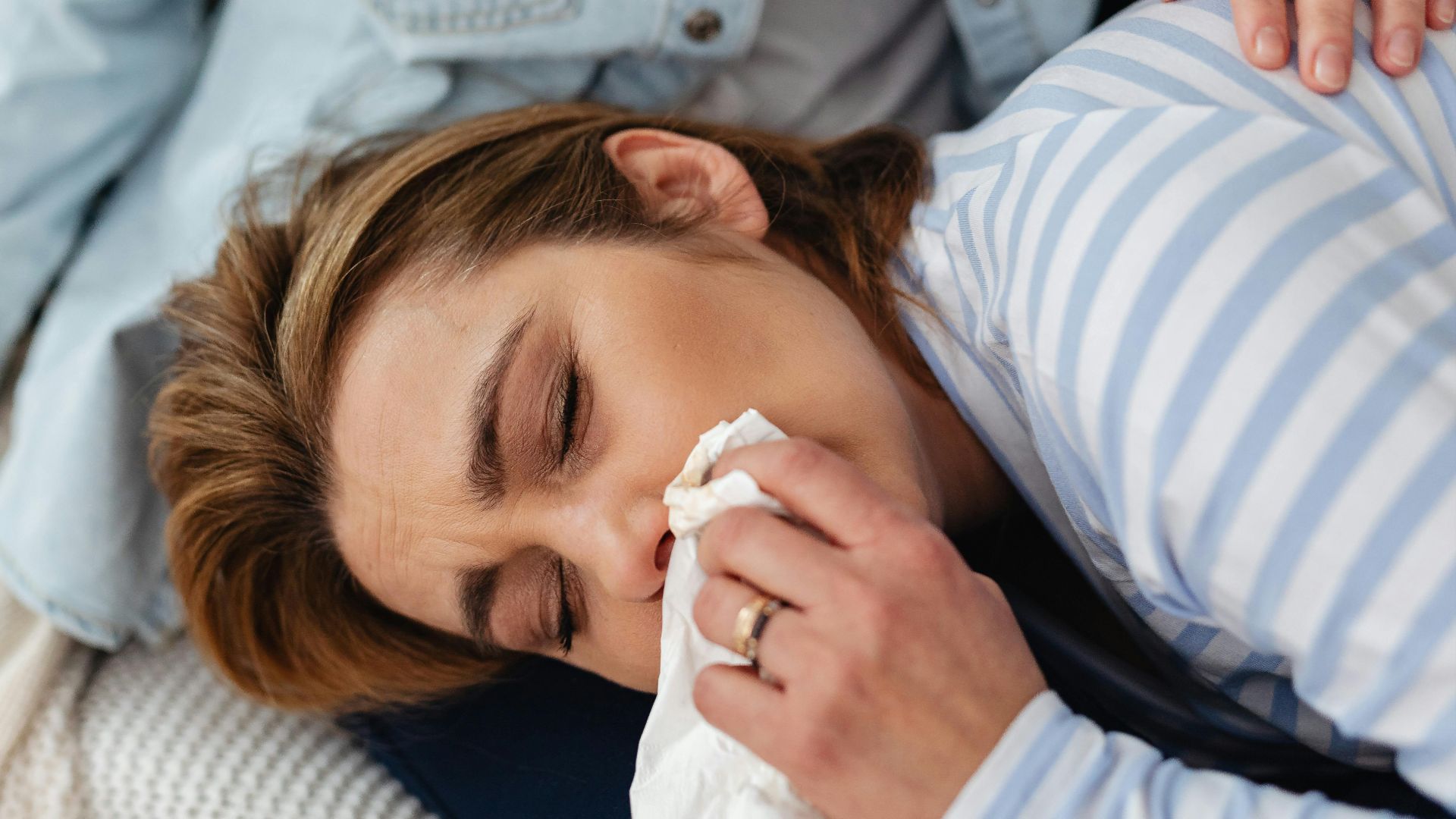 Close-up of a woman in distress being comforted indoors.