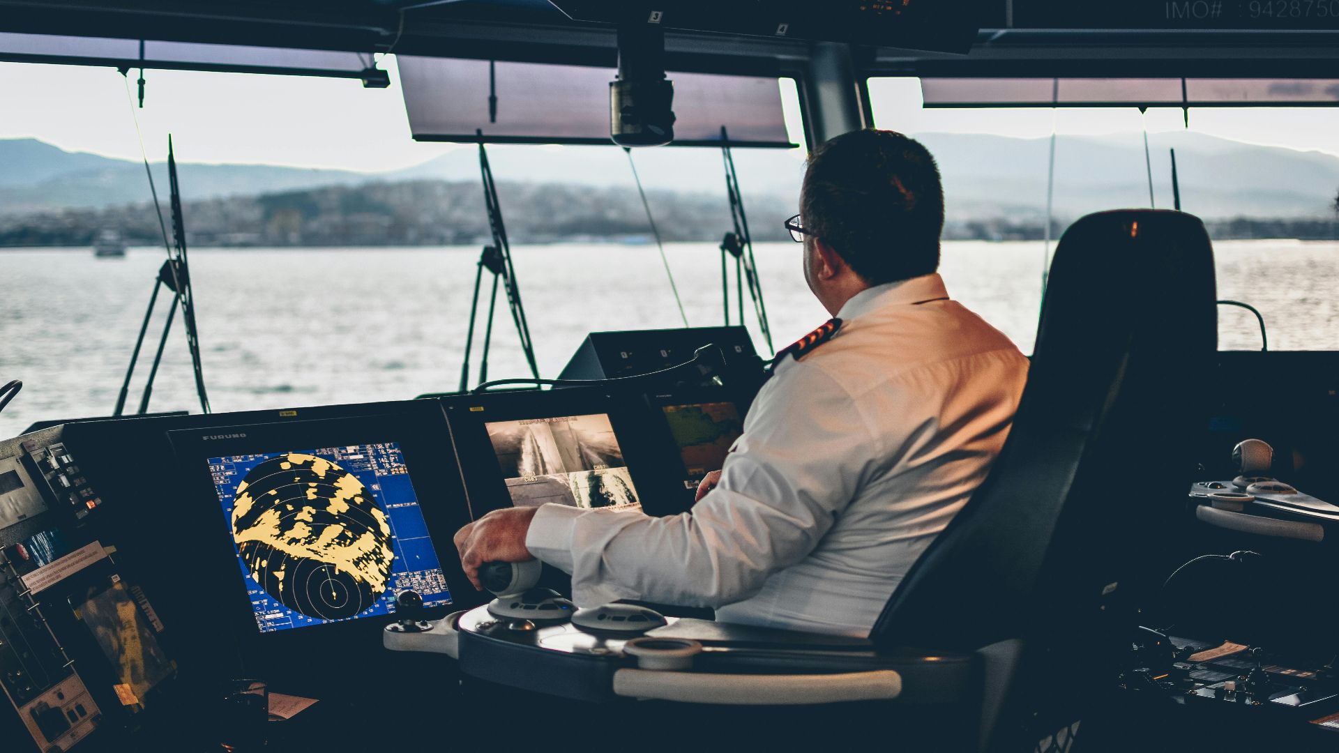 Ship captain operates navigation systems overlooking Istanbul waters. Maritime expertise at its finest.