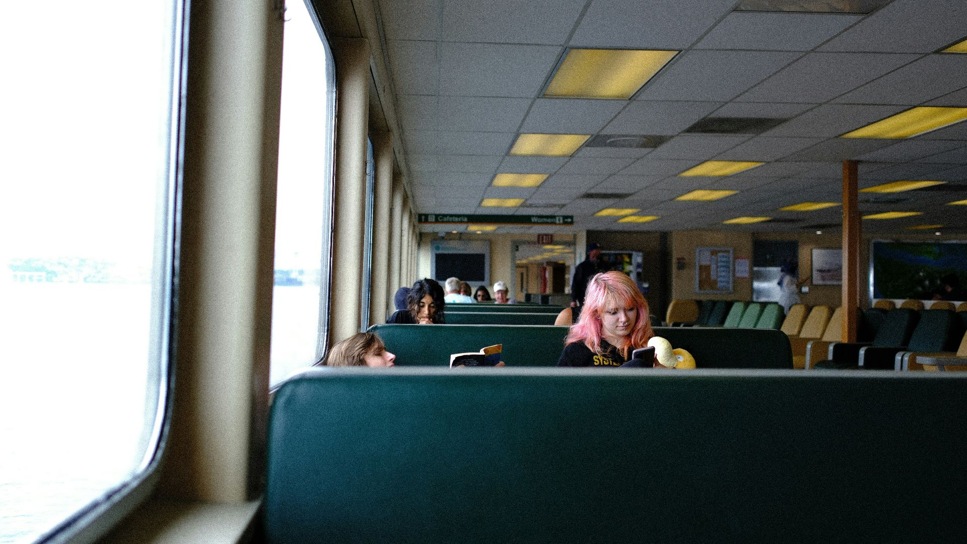 A woman sitting at a table next to a window