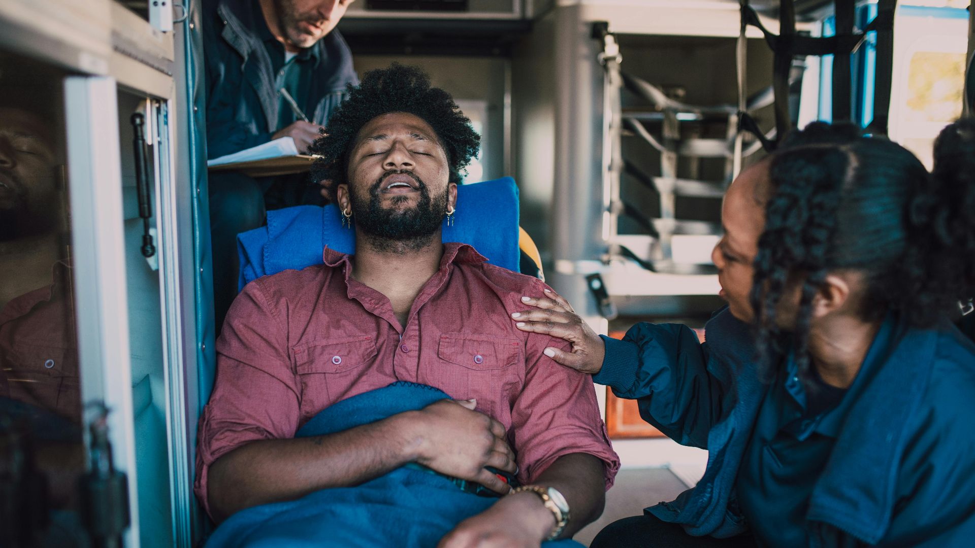 Paramedics attend to a patient inside an ambulance, offering emergency medical care.