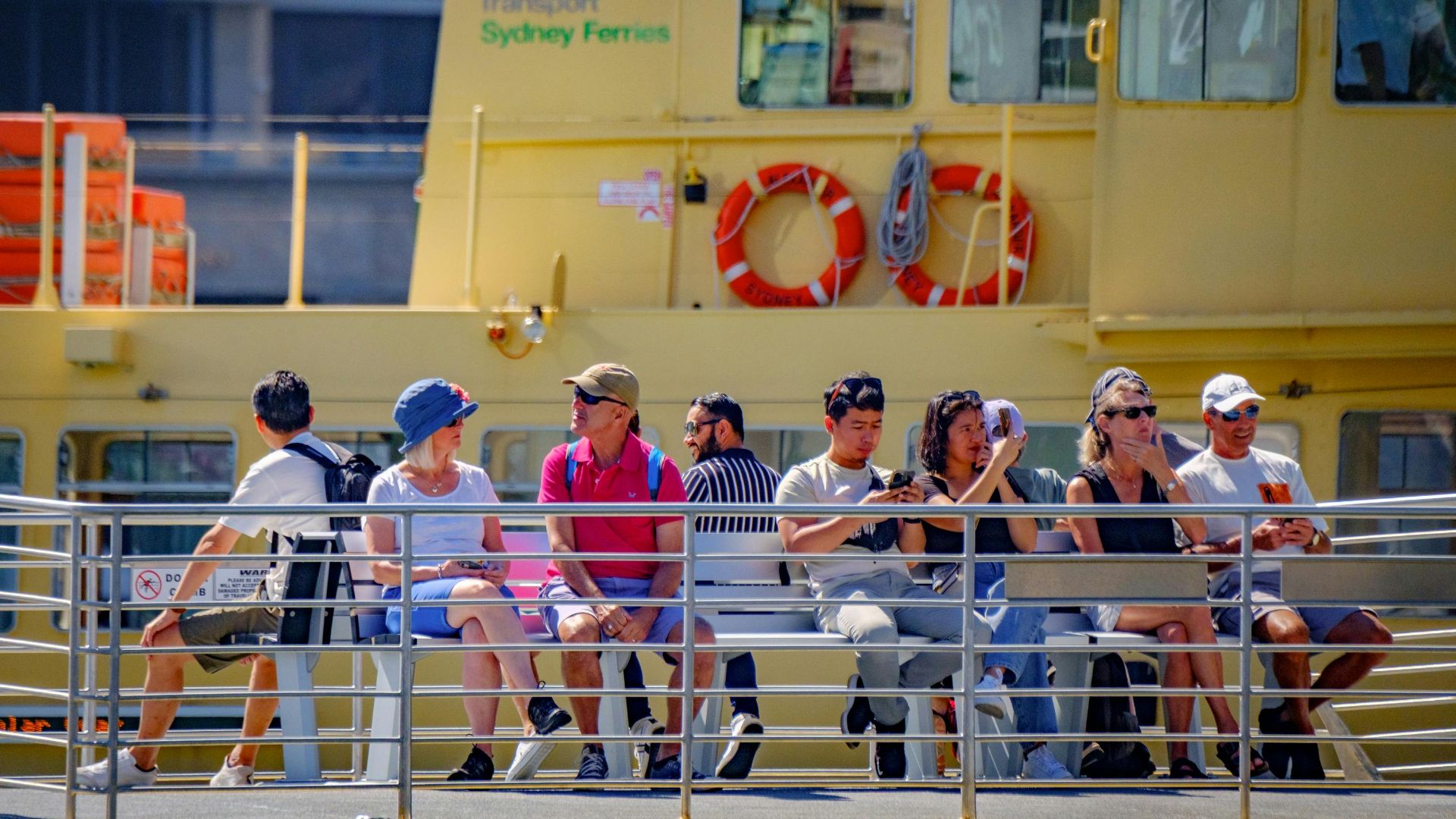 Passengers aboard Sydney Ferry enjoy a sunny day, showcasing leisure and travel.