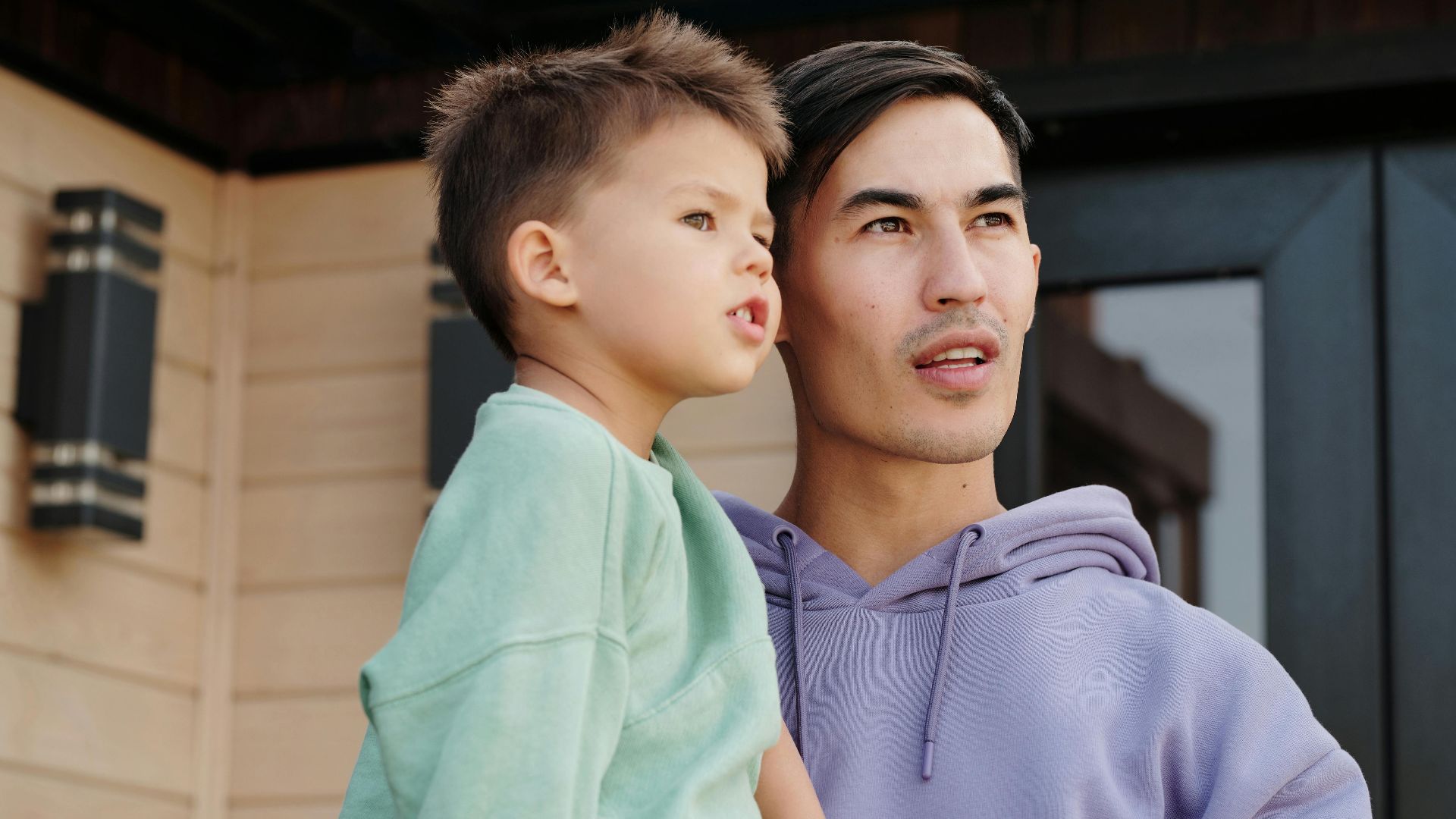 Father and son looking into the distance while enjoying a moment together outside.