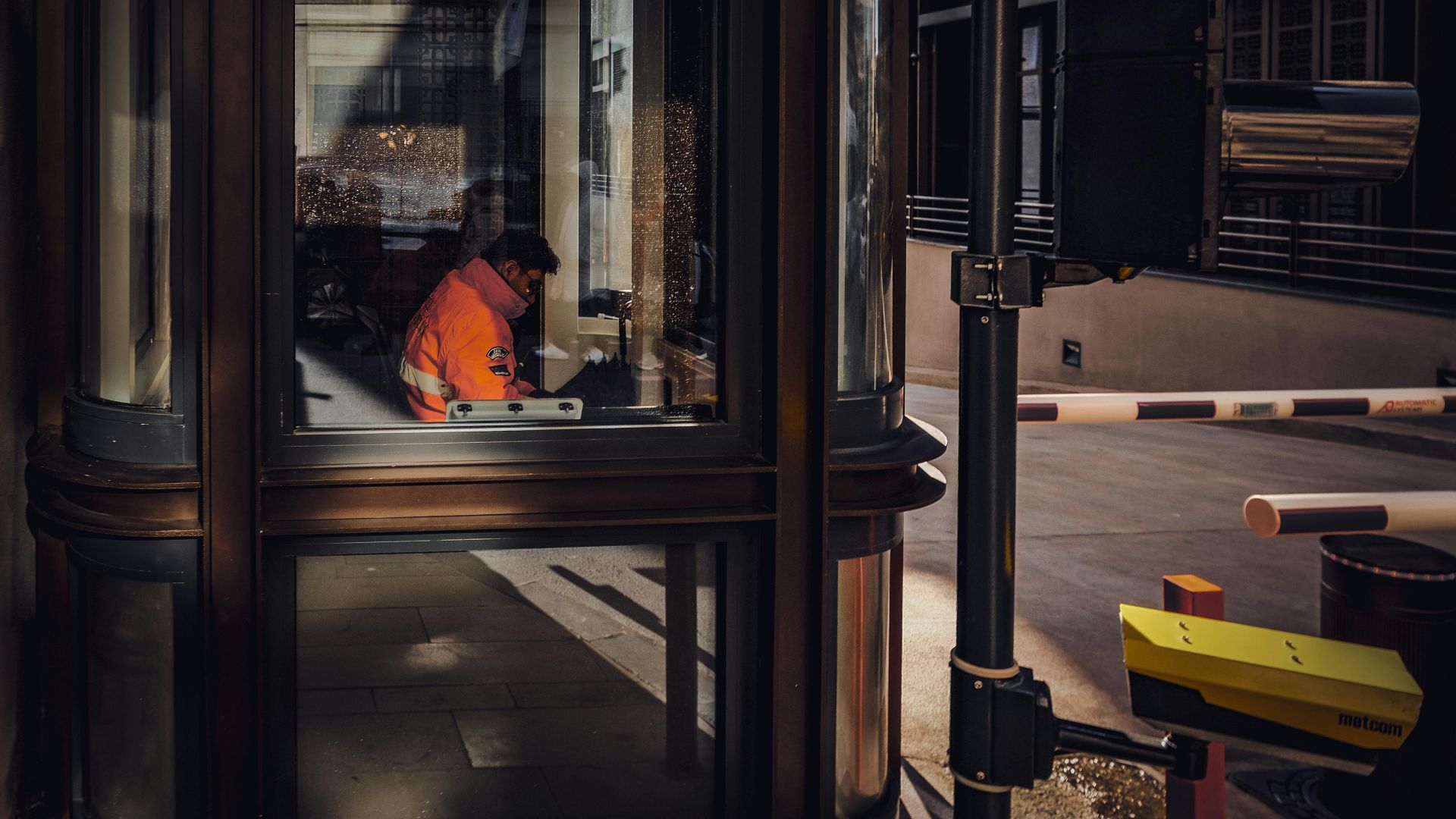 A security guard sitting inside a glass booth in Istanbul, Türkiye.