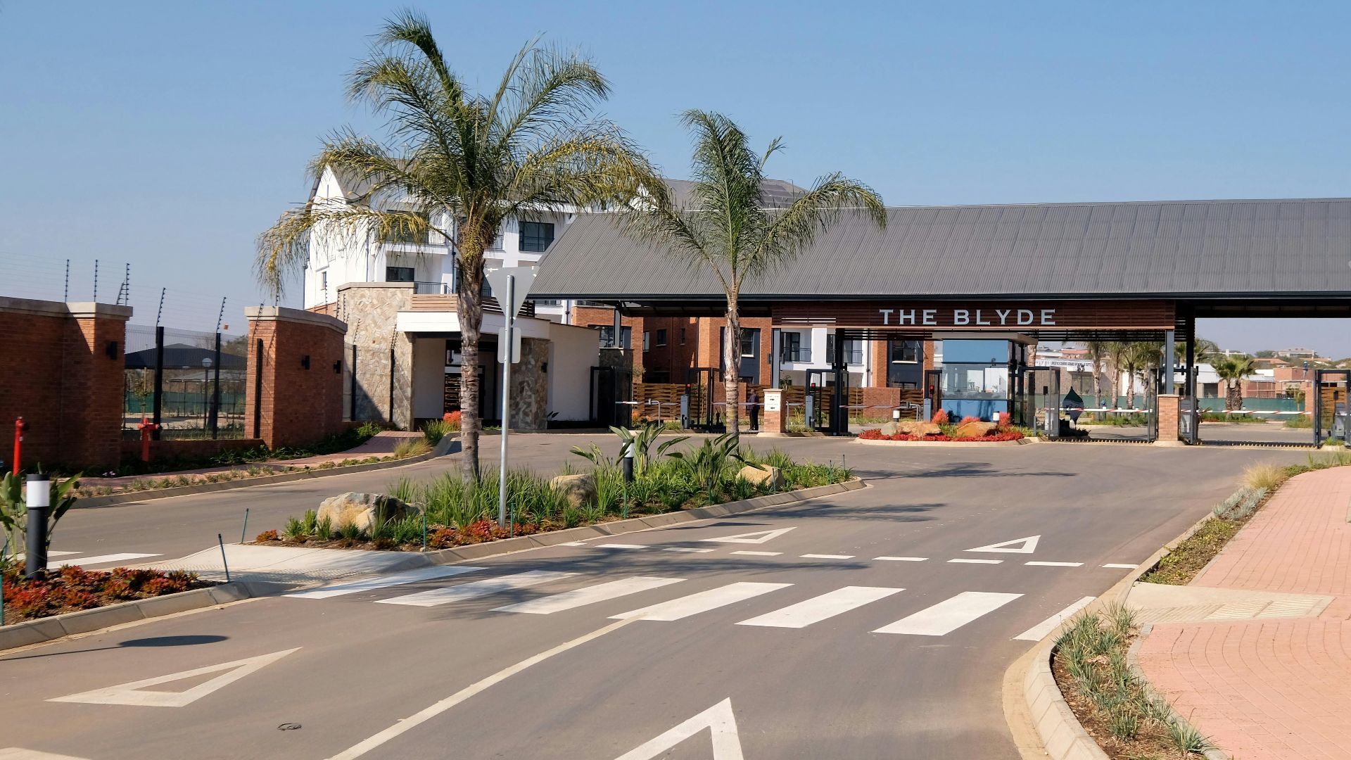 Entrance to The Blyde residential complex showcasing modern architecture and palm trees.