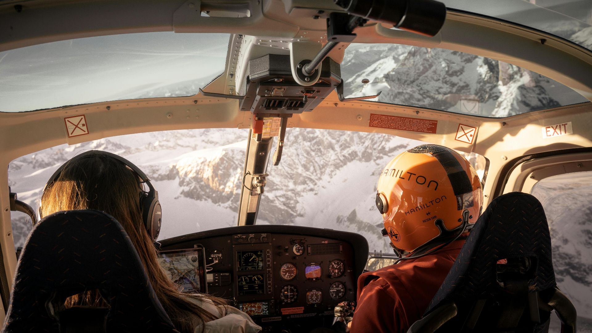 Explore the stunning snowcapped peaks of the Swiss Alps from a helicopter cockpit. Adventure awaits.