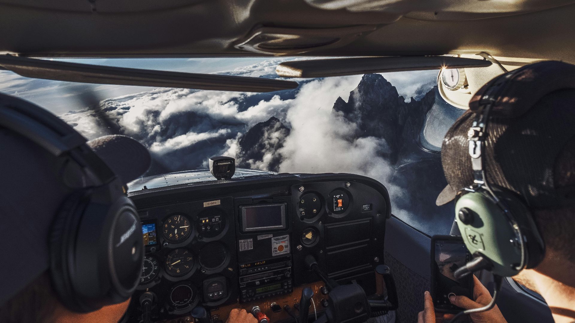 Pilot's perspective of flying over clouds and mountains, capturing the breathtaking view.