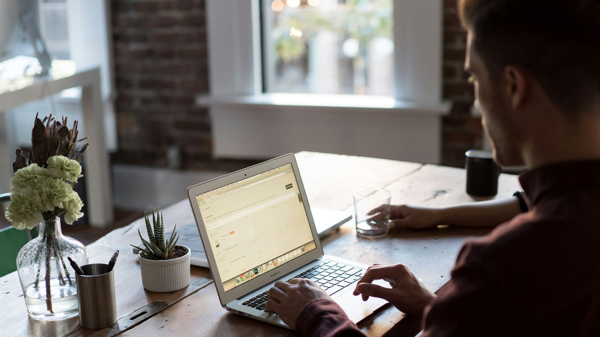 man operating laptop on top of table