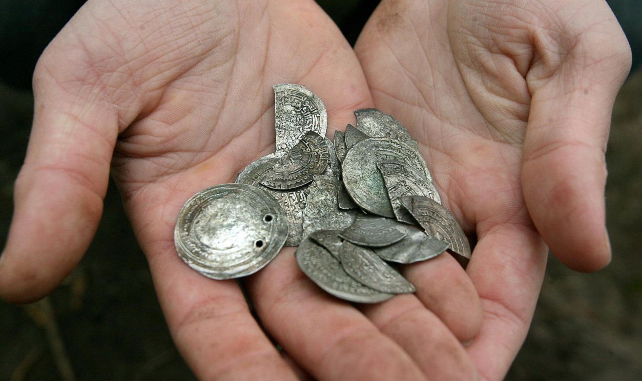 Getty Images - 72298980 - A handful of Arabic 10th century silver coins found by brothers Arvid and Edvin Sandborg on the Swedish island of Gotland is shown 30 October, 2006. The 1,100 coins, along with several silver bracelets, formed a three-kilo viking treasure trove that the brothers found buried on a neighbor's property last week.