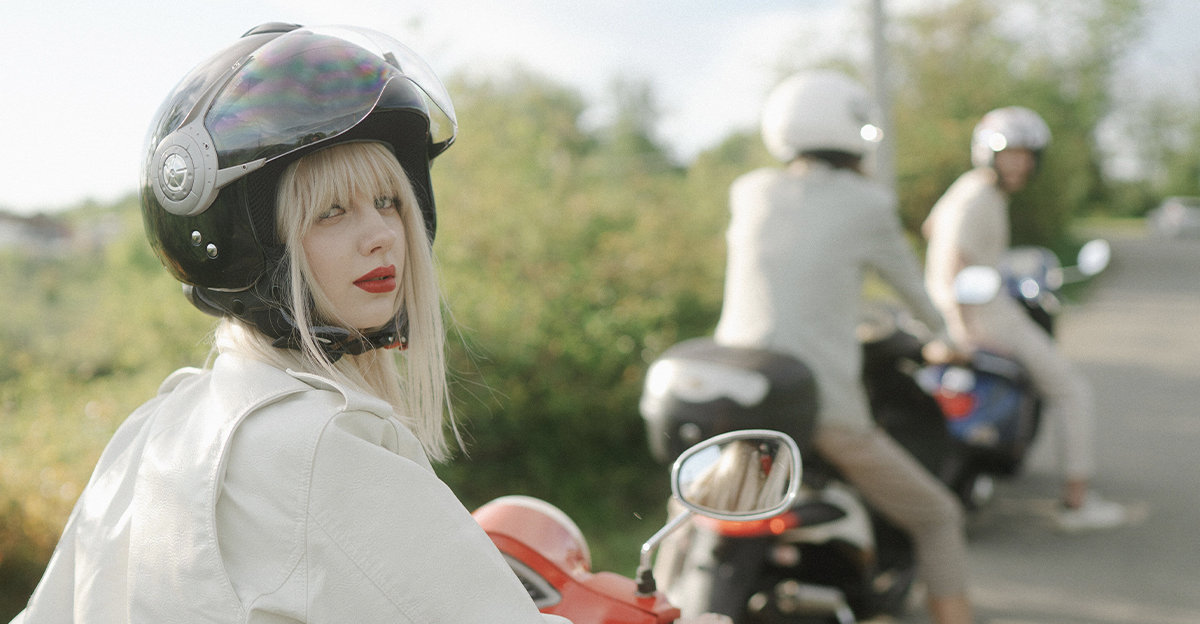Woman on a scooter, wearing a helmet.