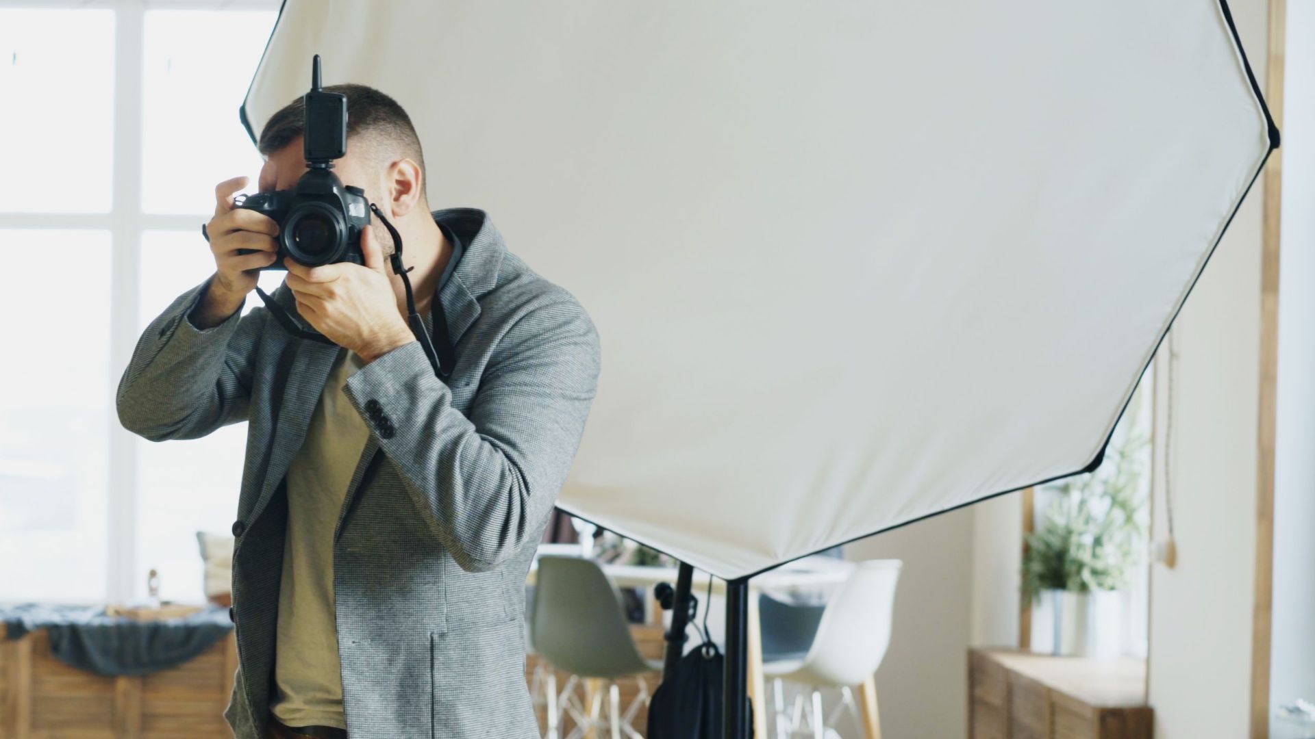 Photographer capturing a subject in a professional studio with equipment setup.